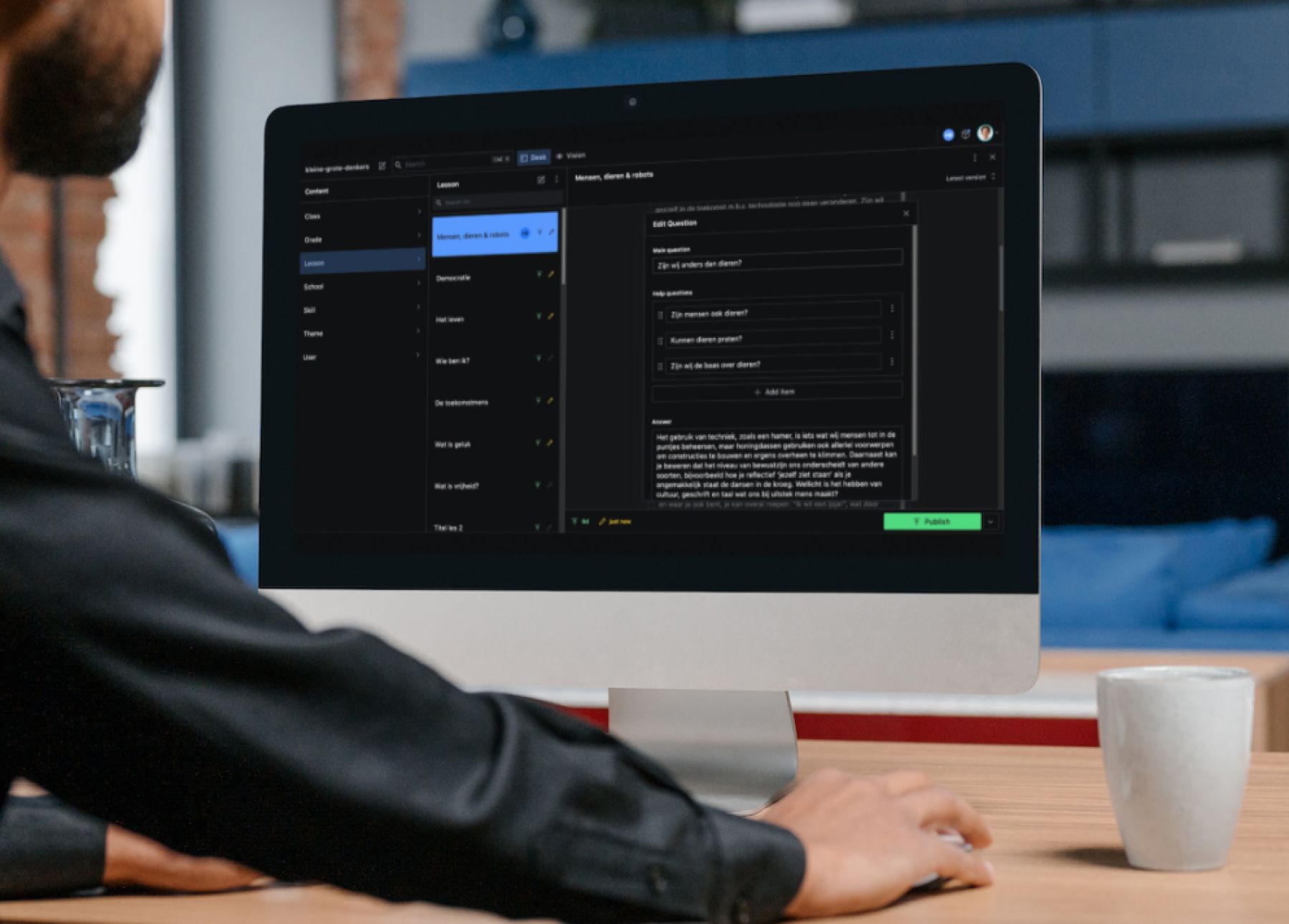 Een persoon achter een computerscherm met daarop een content management systeem